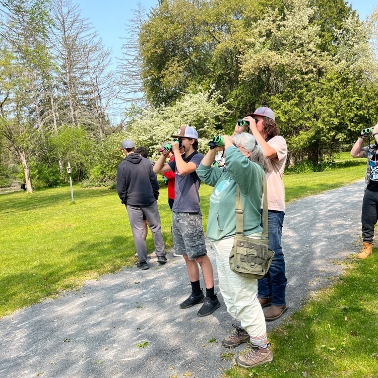 group of students using binoculars